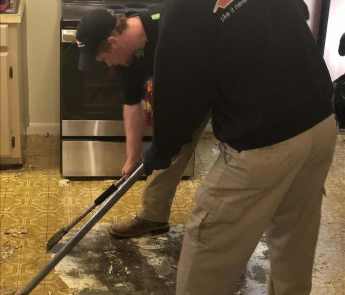photo of Eman and Casey scraping floors